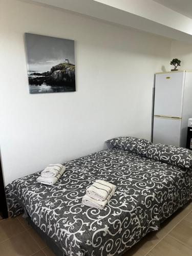 a bedroom with a bed with a black and white blanket at Sunset apartment in Tivat