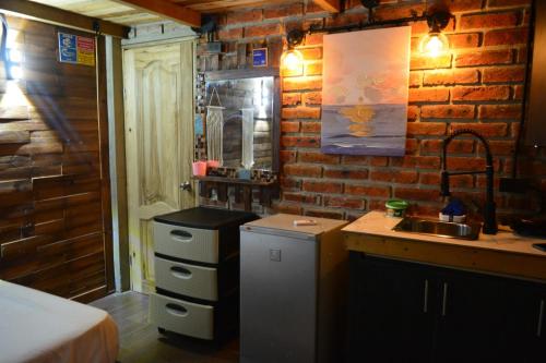 a kitchen with a sink and a brick wall at MARIBAO in Playas