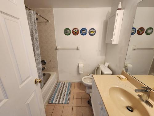 uma casa de banho branca com um lavatório e um WC em Scarborough Townhouse em Toronto