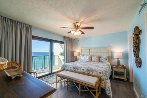 um quarto com uma cama e uma varanda com o oceano em Commodore 1306 'Dream Come True' em Panama City Beach