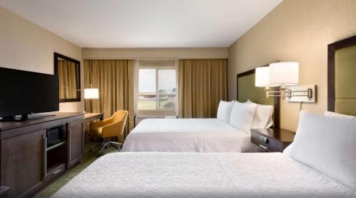 pokój hotelowy z 2 łóżkami i telewizorem w obiekcie Summit Suites w mieście Gillette