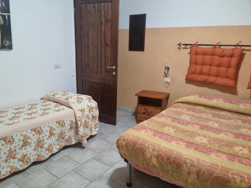 ein Hotelzimmer mit 2 Betten und einer Tür in der Unterkunft Sa Omu Ticci in Seùlo