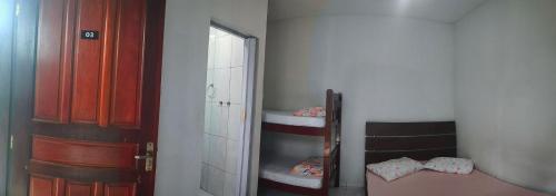 a small room with a mirror and a bunk bed at Suítes Para Casal in Bertioga