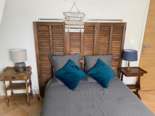 een slaapkamer met een bed met blauwe kussens bij LE MASKALOU in La Colle-sur-Loup