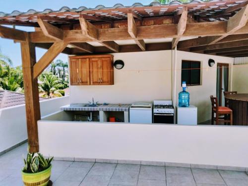 an outdoor kitchen with a wooden pergola at Okaina Studio Rooftop in Cabarete