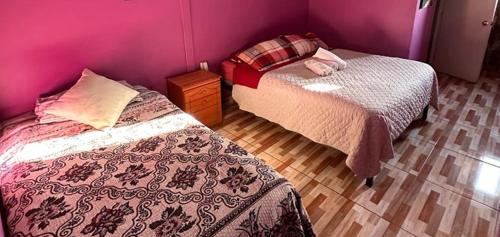 um quarto com 2 camas e uma parede roxa em Hotel 66 em Santiago