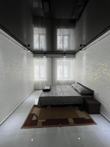 um quarto com uma cama e uma grande janela em Grozno 6 em Tbilisi