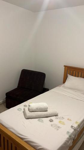 ein Bett mit einem Stuhl und einem Handtuch darauf in der Unterkunft Sweet Home in Bristol