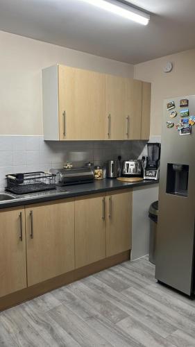 eine Küche mit Holzschränken und einem Kühlschrank in der Unterkunft Sweet Home in Bristol