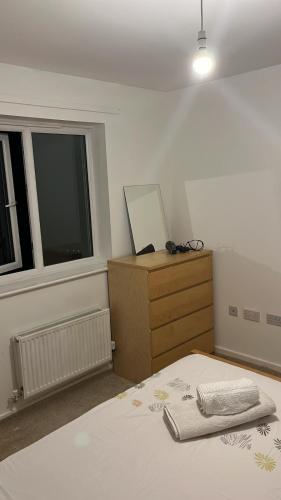 ein Schlafzimmer mit einem Bett, einer Kommode und einem Fenster in der Unterkunft Sweet Home in Bristol