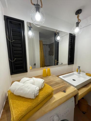 uma casa de banho com um lavatório e um espelho em Lever du soleil em La Trinité