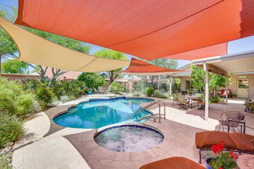 a swimming pool with an umbrella on a patio at Patio and Pool Access Sunny Phoenix Casita! in Phoenix