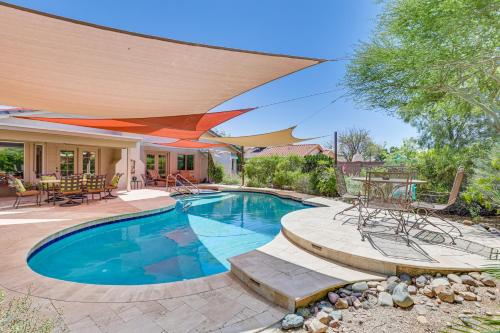 a swimming pool with an umbrella and a patio at Patio and Pool Access Sunny Phoenix Casita! in Phoenix