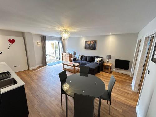 uma sala de estar com um sofá e uma mesa em Stansted Airport Stay, Parking and Luxury Suite em Birchanger