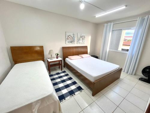um quarto com 2 camas e uma janela em Casa Ampla - Ótima Localização em Piracicaba