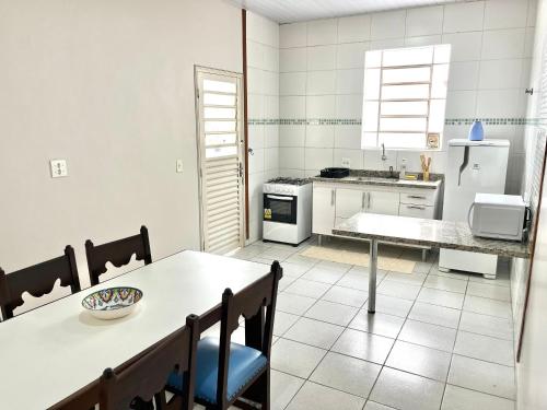 Casa Ampla - Ótima Localização في بيراسيكابا: مطبخ مع طاولة وطاولة وكراسي