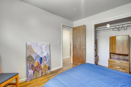 a bedroom with a blue bed and a painting on the wall at Salt Lake City Home Close to Trails and Museums! in Salt Lake City