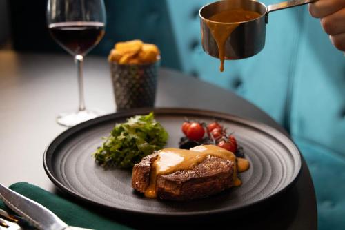 a plate of food and a glass of wine at Hotel Indigo - Dundee by IHG in Dundee