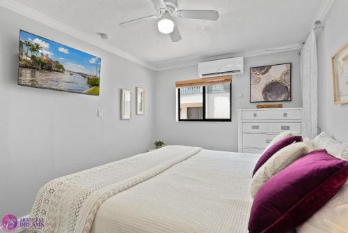 una camera bianca con un grande letto con cuscini viola di Beach Road Condo, Patio, Siesta Key Village and Beach Walkable a Siesta Key