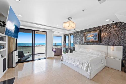 3 Story Oceanfront Home with Jacuzzi in Newport Beach on the Sand! في شاطئ نيوبورت: غرفة نوم مع سرير وإطلالة على المحيط