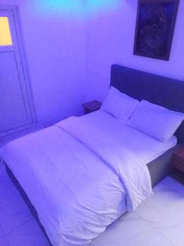 a bedroom with a large bed with white sheets and pillows at Ge-Mart Hotels and Suites in Lagos