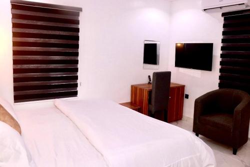 1 dormitorio con cama, silla y escritorio en Ge-Mart Hotels and Suites, en Lagos
