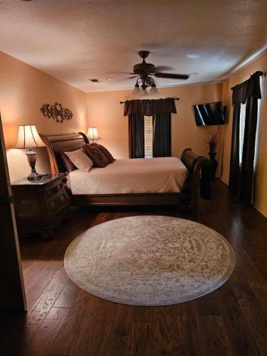 a bedroom with a bed with a ceiling fan and a rug at The Lodge at Harmony Oaks in Weatherford