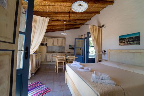 uma cozinha e sala de estar com mesa e cadeiras em Residence Isola dei Mori em SantʼAntìoco