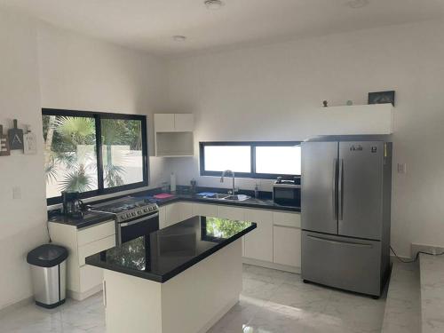 a kitchen with a stainless steel refrigerator and a sink at Casa Kukulkan 1 in Puerto Morelos