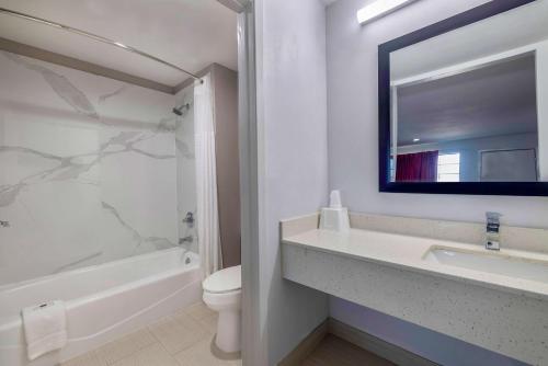 a bathroom with a sink and a toilet and a mirror at Motel 6 Lake Charles, LA in Lake Charles