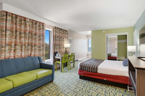 um quarto de hotel com uma cama e um sofá em Best Western Plus Holiday Sands Inn & Suites em Norfolk