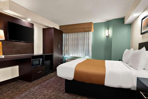 a hotel room with a bed and a flat screen tv at Quality Inn Memphis Northeast near I-40 in Memphis