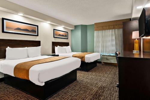 a hotel room with two beds and a flat screen tv at Quality Inn Memphis Northeast near I-40 in Memphis