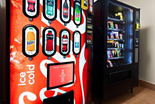 a cocacola soda machine next to a drink refrigerator at Quality Inn Memphis Northeast near I-40 in Memphis