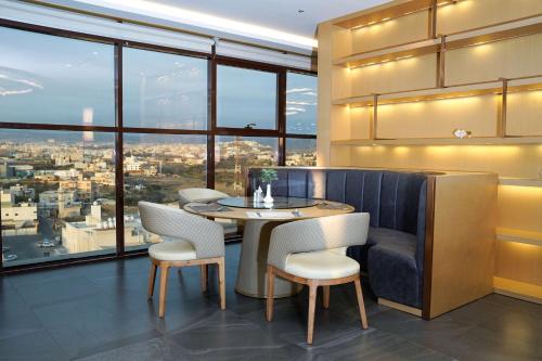 a dining room with a table and chairs and a large window at Best Western Plus Danat Almansak Hotel in Abha