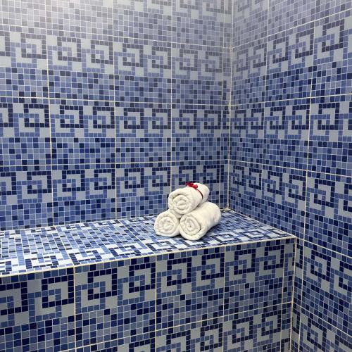 a bathroom with blue and white tiled walls and towels at Best Western Plus Danat Almansak Hotel in Abha