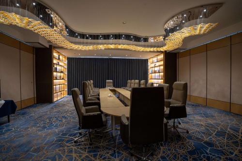 Best Western Plus Danat Almansak Hotel في أبها: قاعة المؤتمرات مع طاولة وكراسي طويلة