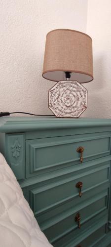 a lamp on top of a dresser next to a bed at Cantinho d'Alice in Valezim