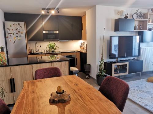 a kitchen and dining room with a wooden table and chairs at Chambre chez habitant proche Métro in Toulouse