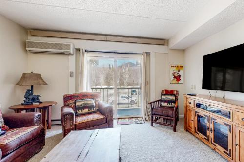 a living room with a flat screen tv and furniture at Autumn Colors Condo, Unit 215 in Lincoln