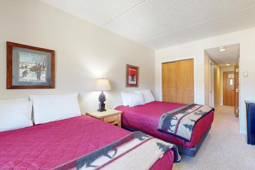 two beds in a hotel room with red sheets at Autumn Colors Condo, Unit 215 in Lincoln