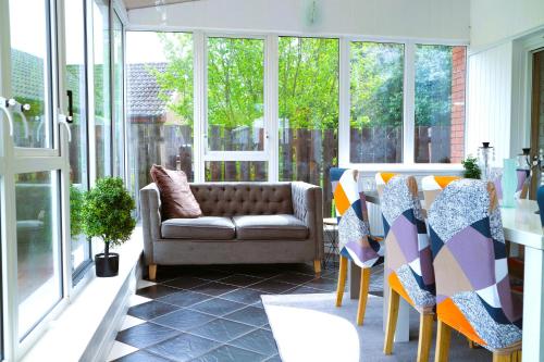 a living room with a couch and some windows at Duddingston Guest House in Edinburgh