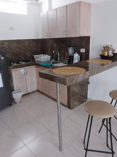 a kitchen with a counter and two stools in it at Edificio Tony - Alojamiento Aparta-Hotel in Barrancabermeja