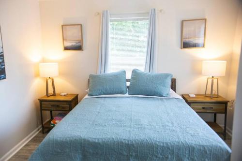 1 dormitorio con 1 cama azul y 2 mesitas de noche en Cozy Cottage only 4 Blocks from the Ocean en Jacksonville Beach