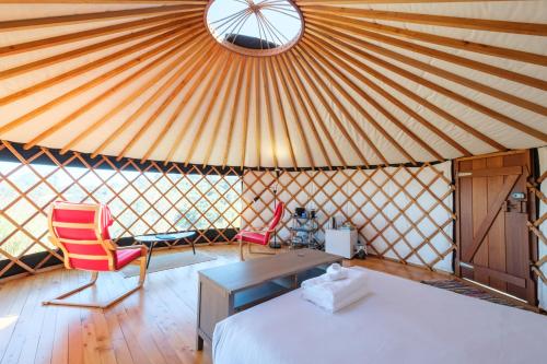 a yurt with a bed and a table and chairs at Awaawa - Rangi Yurt in Palm Beach