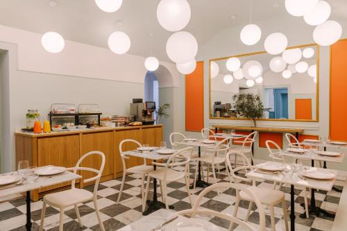 restauracja z białymi stołami i krzesłami oraz blatem w obiekcie The Sonetto powered by Sonder we Florencji