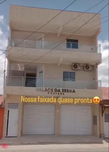 a building with a garage door in front of it at Flats Palace da serra in Serra de São Bento