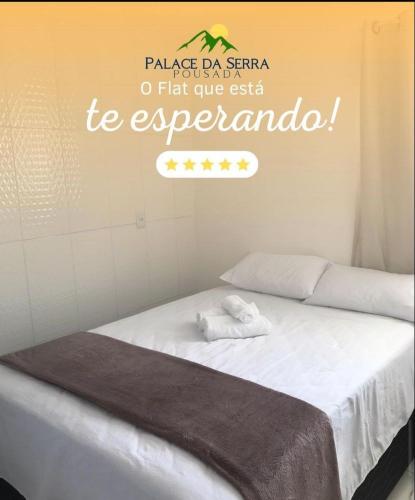 een slaapkamer met een bed met een bord aan de muur bij Flats Palace da serra in Serra de São Bento