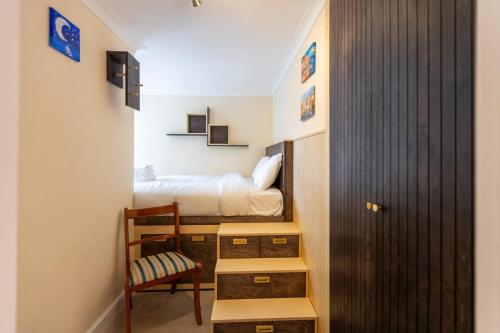 um pequeno quarto com uma cama e uma cadeira em Westminster Charm with Roof Terrace em Londres