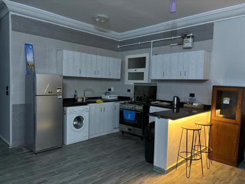 a kitchen with a stove and a washer and dryer at Heliopolis Residence Shorouk city, Cairo (premium) in Madīnat ash Shurūq